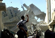 Palestinian children throw stones at an armored bulldozer